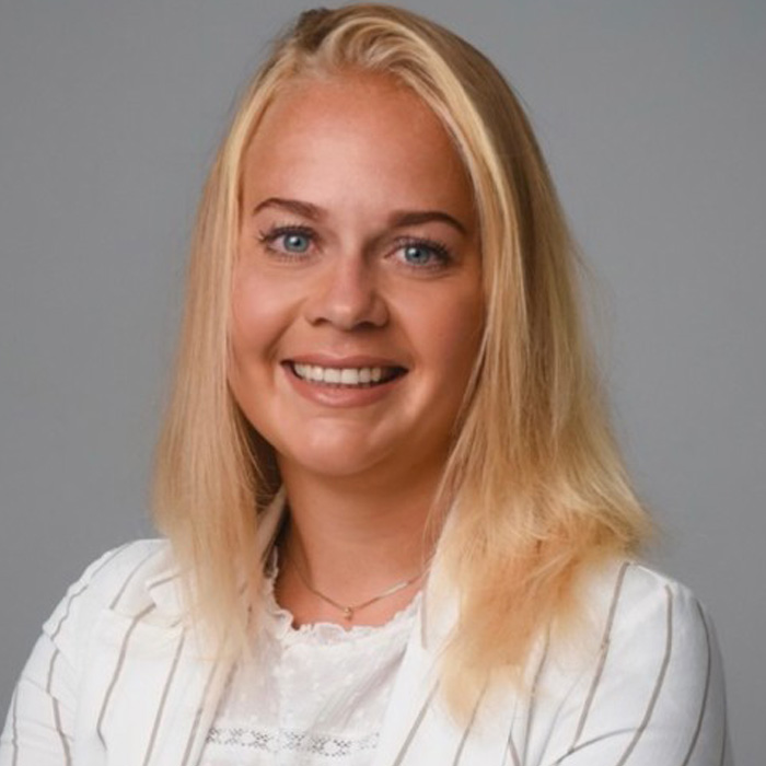 A woman with blond hair smiles at the camera